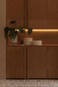 Warm and inviting kitchen with wooden cabinets and a wooden countertop, featuring a bowl and cup, and two potted plants