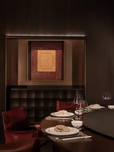 A dining room with a wooden table and chairs set for a meal, creating a warm and inviting atmosphere