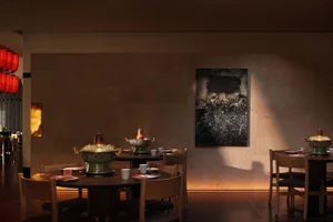 Warm and inviting dining space with a large wooden table, stone walls, and a mix of natural and artificial lighting