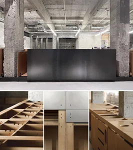 A modern living space with a wooden desk, black counter, and metal refrigerator, featuring a warm and inviting atmosphere with a combination of wood and metal materials