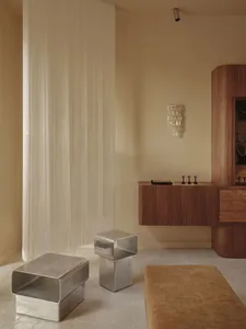 beige bathroom with a wooden vanity, sink, and mirror, surrounded by a couch in a larger living space