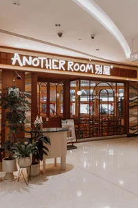 A well-lit restaurant with modern design, marble flooring, and wooden furniture, creating an inviting and comfortable atmosphere