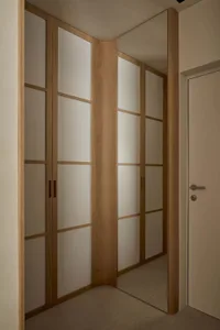 一間昏暗的臥室，具有木造門和柜子，簡單和功能性的風格，著重在木材元素