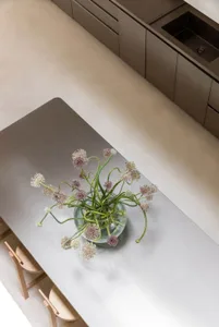一張木桌子上放著一口金屬桌子和一個紫色的花瓶,在室內
