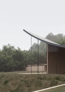 A modern building with a large glass wall, surrounded by a grassy area, with natural light streaming in through the glass wall, creating a bright and inviting atmosphere