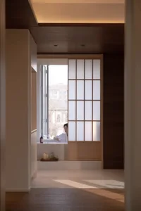 Relaxing bathroom scene with a woman in a bathtub, surrounded by a wooden floor and natural light from a window