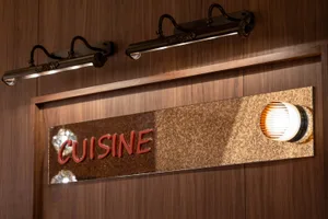 A well-lit restaurant with a wooden sign reading Cuisine, creating a warm and inviting atmosphere