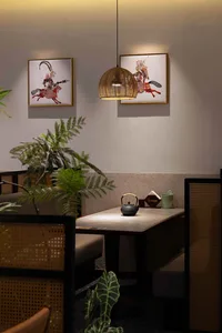 A well-lit restaurant with a dining table, chairs, a potted plant, and a vase, creating a cozy and inviting atmosphere