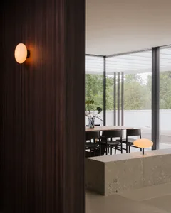 舒適的客廳，沙發、椅子、餐桌、自然光線透進的窗戶，裝飾著花盆和玻璃瓶