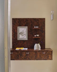 Bathroom with a wooden cabinet, mirror, and picture on the wall, featuring a warm brown and tan color scheme and natural lighting