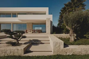 Large modern house with a patio and pool, featuring an open living room, dining area, kitchen, and bedroom with a garden and natural lighting
