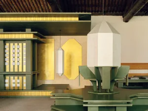 A dining area with a green table, white lamp, and dim lighting, creating a cozy and intimate atmosphere
