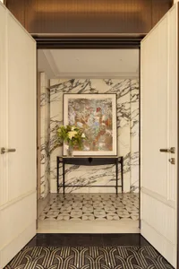 A well-lit hallway with a marble floor, black and white tiles, and a painting on a black frame