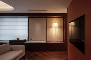 A well-lit living room with a wooden floor, a couch, a chair, and a television, creating a comfortable and inviting atmosphere