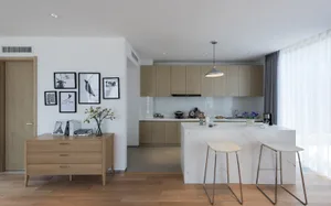 Bright and inviting modern kitchen and dining space with a marble countertop, wooden table, and black oven