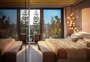 Comfortable living space with two couches and a chair facing a large window, a dining table in the background, and a potted plant near the window