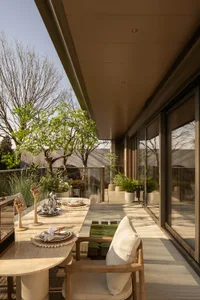 Cozy modern dining space with a set table, natural light, and a potted plant