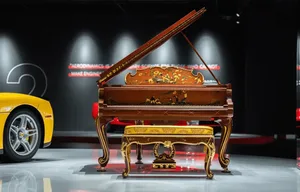 A photograph of a piano in a living space with a hardwood floor, a chair, and a couch in the background, creating an elegant and sophisticated atmosphere
