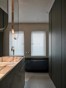 Bathroom with a marble countertop, sink, shower, and bathtub in a dimly lit space
