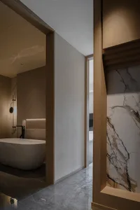 Cozy bathroom with a white bathtub, wooden door, and marble countertop, set against a dimly lit background