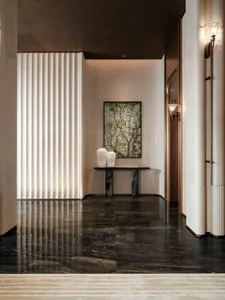 A well-lit modern hallway with a marble floor, white walls, a large painting, and decorative vases