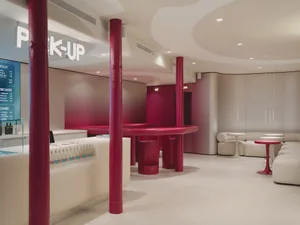 Warm and inviting restaurant with a red counter, table, and chairs, set against a white background