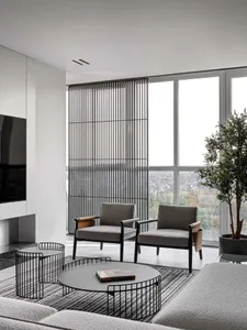 A well-lit, modern living room with a large window, grey furniture, and a potted plant, featuring wood and glass materials