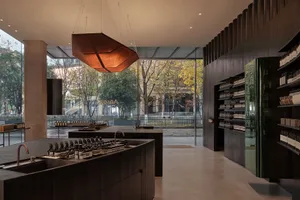 一間現代零售空間，空間敞開，玻璃架，充滿自然光，展示各種瓶子和產品