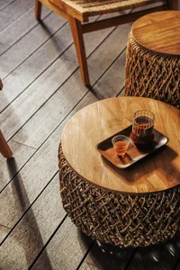 Warm dining area with a wooden floor, table, and chair, featuring two cups and a cozy atmosphere