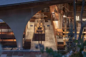 Warm and inviting living and dining area with wooden floors and walls, a dining table, and dim lighting
