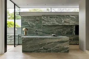 Bright and inviting modern kitchen with a marble countertop, natural light, and a sink
