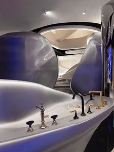 A modern bathroom with a sink, bathtub, and toilet, featuring ceramic or porcelain fixtures in a well-lit and clean space