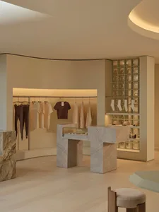 一間光線充足的衣服店裡，整齊地排列的衣櫃和褲子，營造出一種溫馨且有系統的購物環境