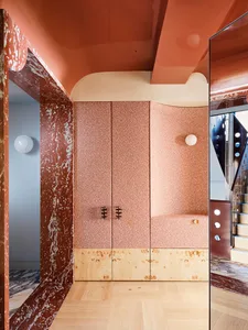 Cozy bedroom with a pink cabinet, pink wall, and pink floor, featuring a bed and dim lighting