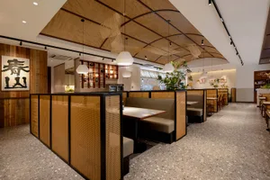 Cozy modern dining space with wooden walls, potted plants, and dim lighting