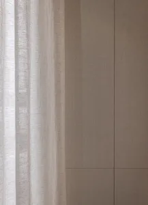 Dimly lit living room with a white curtain covering the window