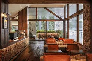 A bright and welcoming cafe with a large window, brown furniture, and a modern design