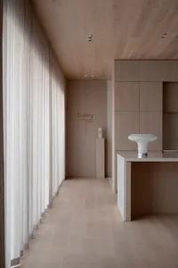 A dimly lit, modern interior space with a large wooden floor, simplicity, and functionality