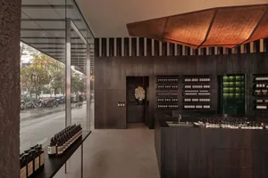 一間木造店鋪，有大玻璃窗，木架上擺滿瓶子和罐子，營造出溫暖和邀人的氛圍