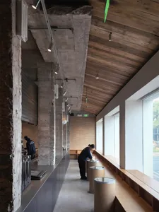 Modern bathroom with a wooden counter, sink, and bench, filled with natural light from the windows
