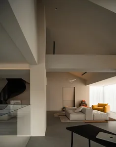 Cozy living space with a white couch, chair, and rug, surrounded by natural light and clean lines
