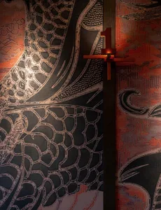 A dimly lit oriental bedroom with a black and white photograph of a dragon design on the wall, set against a bed in a cozy and intimate atmosphere