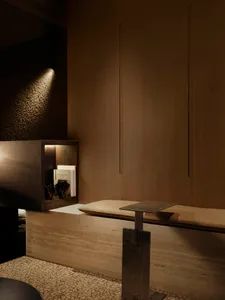 Cozy dining area with a wooden table and bench in a modern space with dim lighting