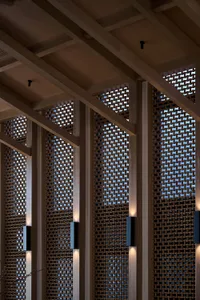 A large room with a wooden ceiling and wooden beams, featuring multiple windows for natural light and a cozy atmosphere