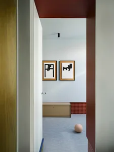 A modern hallway with a brown cabinet, picture frames, and a black and white chair image on the wall, set in a well-lit and inviting space