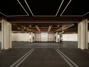 Spacious modern lobby with high ceiling, wooden elements, and a mix of natural and artificial lighting