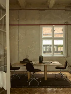 A cozy room with a wooden table and chairs, natural light from a window, and a warm atmosphere