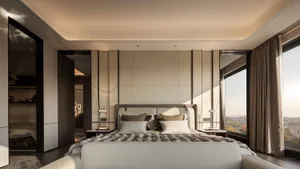 Cozy bedroom with a large bed, a chair, and a couch in a modern space with white walls and soft warm lighting