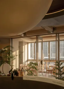 Spacious dining room with multiple chairs and tables, natural light, and a modern aesthetic