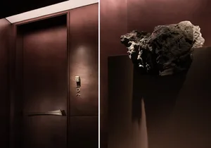 A dark and moody room with a brown door and a rock on top, set against a brown color scheme